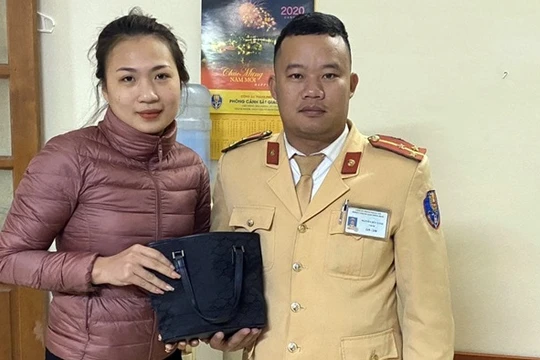 Chị Nguyễn Thùy Linh nhận lại tài sản tại Đội CSGT số 6. Ảnh: Hiệp Bình