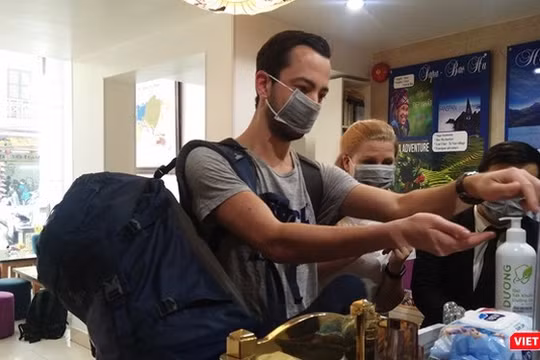 Người nước ngoài thực hiện sát khuẩn tay tại một khách sạn ở Hà Nội.