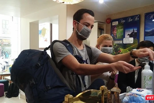 Người nước ngoài thực hiện sát khuẩn tay tại một khách sạn ở Hà Nội.