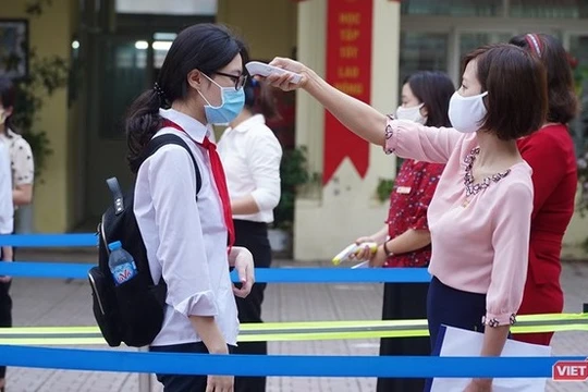 Cán bộ Trường THPT Phan Đình Giót (Hà Nội) đo thân nhiệt cho học sinh. Ảnh: Minh Nhân.