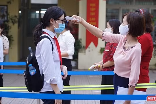 Cán bộ Trường THPT Phan Đình Giót (Hà Nội) đo thân nhiệt cho học sinh. Ảnh: Minh Nhân.