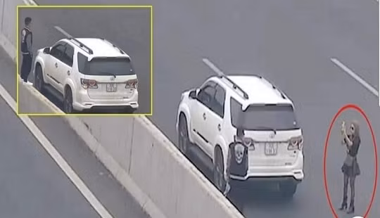 Ảnh cắt từ video ghi lại thời điểm cặp đôi dừng trên cao tốc để sống ảo. Ảnh: Facebook.