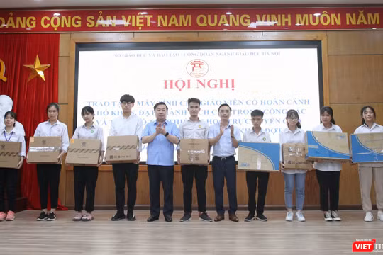 Giám đốc Sở GDĐT Hà Nội Chử Xuân Dũng và Hiệu trưởng trường THCS Thái Thịnh Nguyễn Cao Cường (đại diện nhà tài trợ) trao máy tính cho học sinh có hoàn cảnh khó khăn. Ảnh: Minh Ngọc.