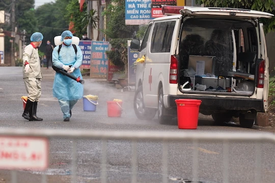 Lực lượng chức năng phun khử khuẩn phía trước ngôi nhà bệnh nhân 243. Ảnh: CDC Hà Nội.