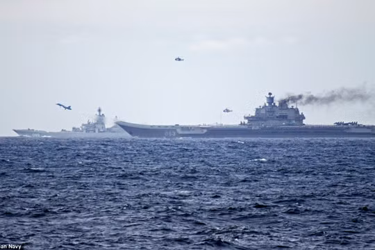 Chiến đấu cơ Su-33 và trực thăng săn ngầm cất cánh từ tàu sân bay Đô đốc Kuznetsov khi cụm tác chiến tàu sân bay Nga hải hành qua eo biển Anh
