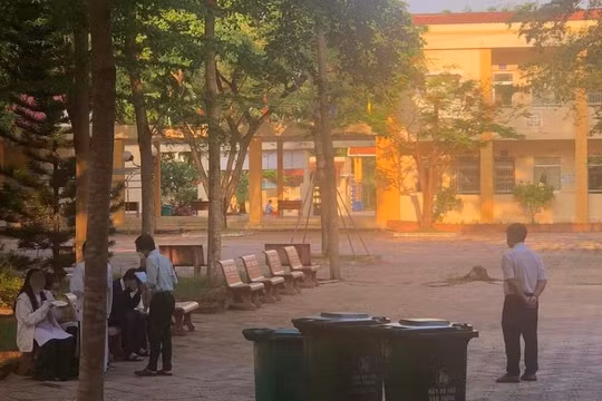 Các học sinh bị thầy phó hiệu trưởng bắt ra ghế đá ở sân trường ngồi ăn thức ăn mà học sinh đã quẳng vào thùng rác. Ảnh Phụ huynh cung cấp 