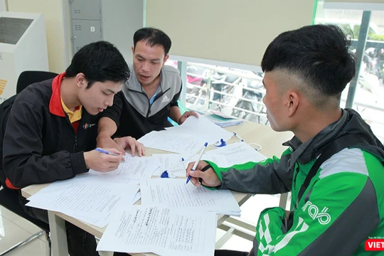 Nhân viên Bưu điện hướng dẫn khách hàng làm thủ tục đăng ký cấp phiếu lý lịch tư pháp tại bưu cục Thăng Long.