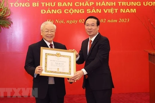 Ông Võ Văn Thưởng, Ủy viên Bộ Chính trị, Thường trực Ban Bí thư trao Huy hiệu 55 năm tuổi Đảng tặng Tổng Bí thư Nguyễn Phú Trọng. (Ảnh: Trí Dũng/TTXVN)