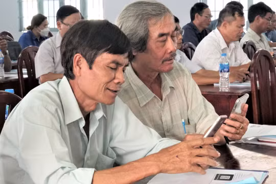 Ông Nguyễn Hồng Lạc (bên trái ảnh) cùng cán bộ đơn vị đã quen thao tác trên các ứng dụng di động và mini app Tây Ninh Smart.