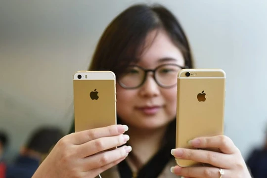 Một khách hàng đang so sánh iPhone SE và iPhone 6S tại một cửa hàng của Apple. Ảnh: CNBC