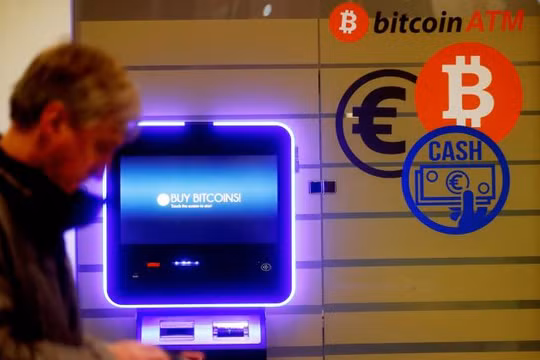 Một người đàn ông đi ngang qua một cây ATM bitcoin ở Vilnius, Litva. Ảnh: CNBC
