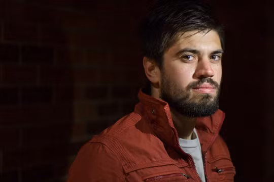 Ảnh chân dung của một người đàn ông với nguồn sáng chính từ đèn flash của điện thoại