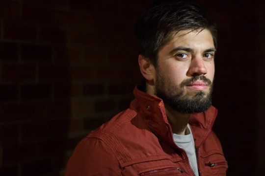 Ảnh chân dung của một người đàn ông với nguồn sáng chính từ đèn flash của điện thoại