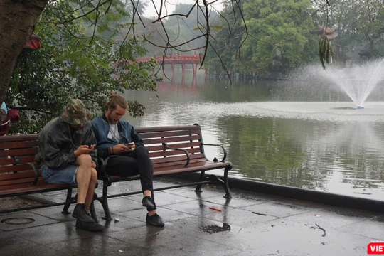 Khách du lịch tận hưởng khoảng lặng hiếm hoi trên đường phố Hà Nội.