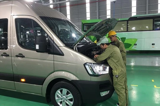 Các công nhân Thaco đang kiểm tra kỹ thuật xe buýt nhỏ Ảnh: Tuấn Nguyễn