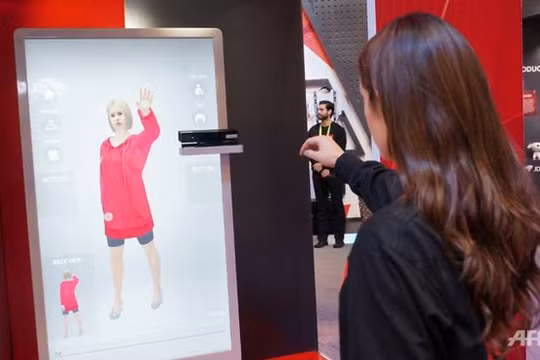 Nhân viên JD.com giới thiệu hệ thống AR cho phép khách hàng thử đồ ảo tại shop. Ảnh: AFP.