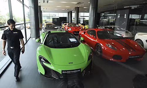 Một viên cảnh sát kiểm tra tại showroom kinh doanh siêu xe đã qua sử dụng bị nghi ngờ buôn lậu ở Thái Lan. Ảnh: Bangkok Post