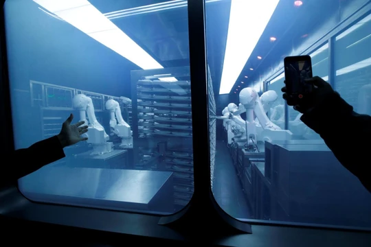 Một khách hàng chụp ảnh một cánh tay robot thu thập các món ăn đóng gói sẵn từ kho lạnh tại nhà hàng lẩu trí tuệ nhân tạo mới của Haidilao ở Bắc Kinh, Trung Quốc. Ảnh: Reuters