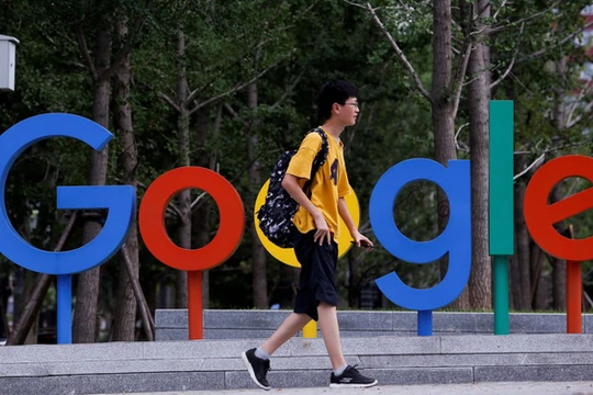 Một thanh niên đi qua khu vực đặt logo Google bên ngoài văn phòng của họ tại thủ đô Bắc Kinh, Trung Quốc - Ảnh: REUTERS