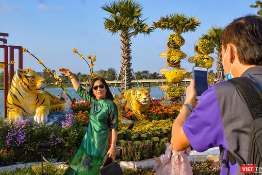 Người dân TP Huế chụp ảnh kỷ niệm với đường hoa xuân Nhâm Dần bên bờ sông Hương (ảnh Tuấn Hiệp)