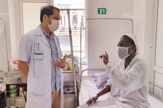 Bác sĩ Trung tâm Bệnh nhiệt đới Bệnh viện Bạch Mai trò chuyện, động viên bệnh nhân bị sốt rét ác tính trong những ngày điều trị (ảnh BV cung cấp)