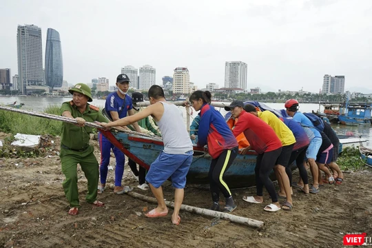 Lực lượng công an hỗ trợ người dân đưa tàu thuyền lên bờ tránh bão