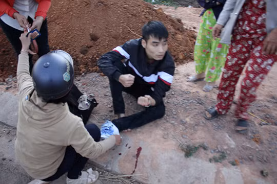Một nạn nhân tại thị trấn Đắk Hà bị xe điên tông đang ngồi bên vệ đường đợi xe cấp cứu - Ảnh do bạn đọc cung cấp