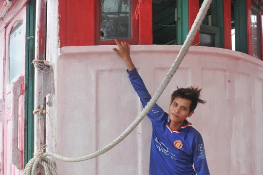 Một ngư dân chỉ vết đạn bắn trên thân tàu