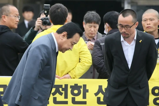 Thủ tướng Hàn Quốc Lee Wan-Koo cúi đầu trong lễ kỷ niệm một năm thảm họa chìm phà Sewol - Ảnh: Reuters 