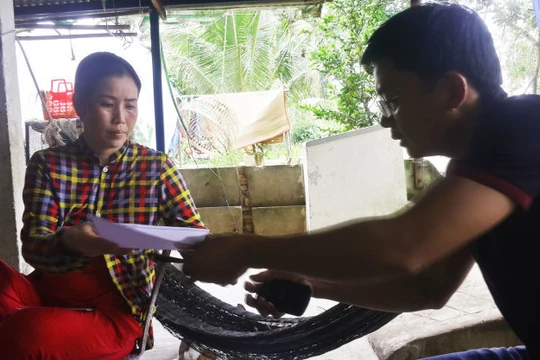 Chị Nguyễn Thị Kim Phương - vợ ngư dân Ngô Văn Sinh - ký đơn nhờ luật sư khởi kiện - Ảnh: K.Nam