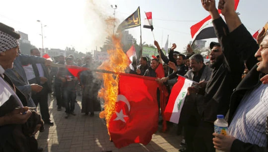 Người biểu tình Iraq đốt cờ Thổ Nhĩ Kỳ, phản đối việc nước này triển khai quân đội đến Iraq mà không xin phép - Ảnh: Reuters