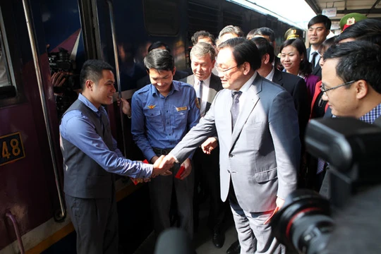 Bí thư Thành ủy Hà Nội Hoàng Trung Hải lì xì và động viên các lái tàu - Ảnh: T.Phùng