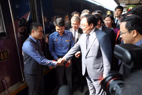 Bí thư Thành ủy Hà Nội Hoàng Trung Hải lì xì và động viên các lái tàu - Ảnh: T.Phùng