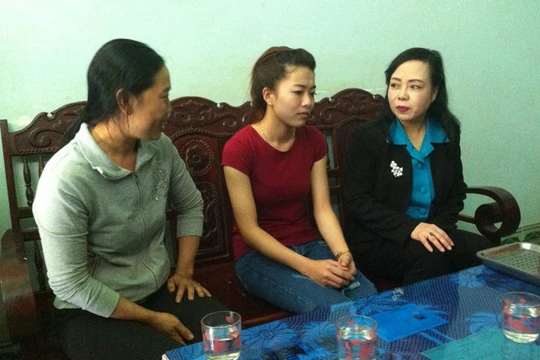 Bộ trưởng Nguyễn Thị Kim Tiến (bìa phải) thăm hỏi đại diện gia đình em Vi - Ảnh: Hà Bình