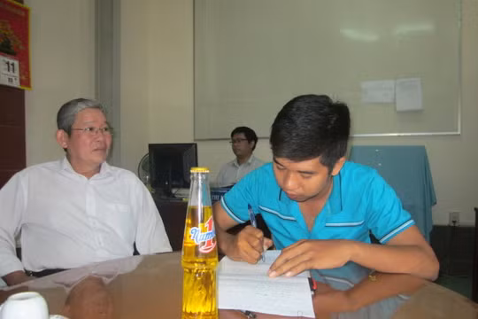 Ông Nguyễn Văn Lợi hướng dẫn anh Định (phải) làm thủ tục khiếu nại - Ảnh: Hoài Thương