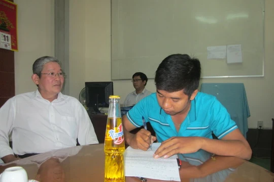 Ông Nguyễn Văn Lợi hướng dẫn anh Định (phải) làm thủ tục khiếu nại - Ảnh: Hoài Thương