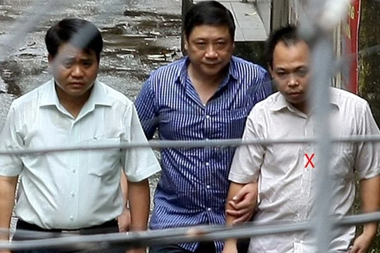 Thiếu tướng Chung (trái) cùng Bình (ngoài cùng bên phải) ra xe về trụ sở công an