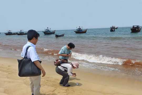 Cơ quan chức năng lấy mẫu nước tại vùng biển có màu đỏ để xét nghiệm - Ảnh: Nguyệt Anh