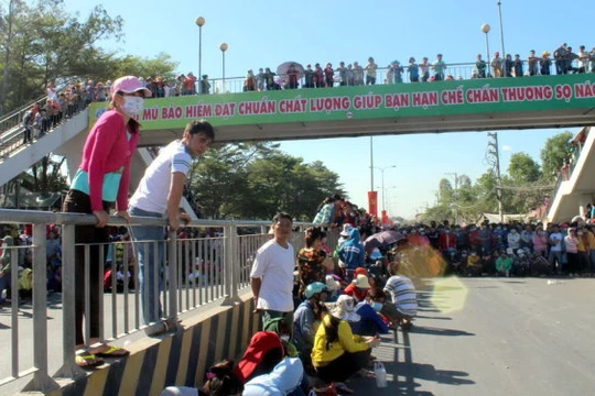 Công nhân tràn ra Quốc lộ 1K, đoạn qua xã Hóa An, TP.Biên Hòa, Đồng Nai khiến giao thông tắc nghẽn - Ảnh: A.L.