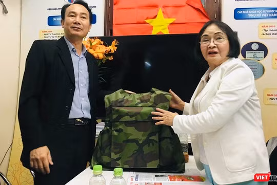 Đại diện Z117 và PGS.TS. Nguyễn Thị Hòe giới thiệu chiếc áo chống đạn sẽ được sử dụng sơn chống đạn và sơn chống cháy. (Ảnh: T.H)