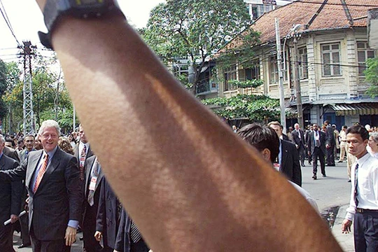 Ngày 18/11/2000, người dân TP.HCM vẫy chào Tổng thống Clinton khi ông đi bộ trên khu phố gần Bảo tàng Mỹ thuật TP.HCM. Ảnh: Hoàng Đình Nam (AFP).