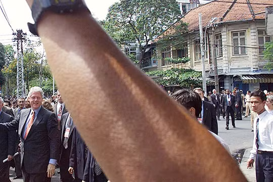 Ngày 18/11/2000, người dân TP.HCM vẫy chào Tổng thống Clinton khi ông đi bộ trên khu phố gần Bảo tàng Mỹ thuật TP.HCM. Ảnh: Hoàng Đình Nam (AFP).