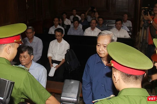 Các bị cáo Nguyễn Hữu Tín và Đào Anh Kiệt trong vòng vây của cảnh sát bảo vệ tại tòa. Ảnh: GVT.