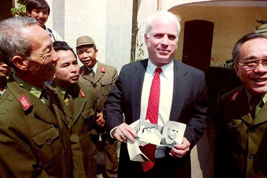 2-	Thượng nghị sỹ John McCain cầm những tấm hình đen trắng chụp ông khi bị bắt làm tù binh ở Hà Nội năm 1967 trong một chuyến đến thăm Bảo tàng quân đội nhân dân Việt Nam ngày 9/10/1992.Ảnh: Hoàng Đình Nam/ AFP.