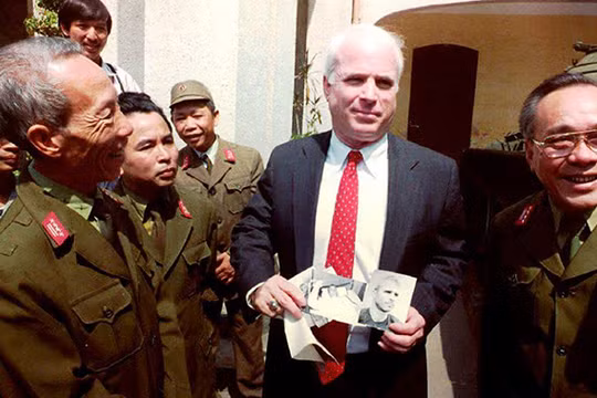 2-	Thượng nghị sỹ John McCain cầm những tấm hình đen trắng chụp ông khi bị bắt làm tù binh ở Hà Nội năm 1967 trong một chuyến đến thăm Bảo tàng quân đội nhân dân Việt Nam ngày 9/10/1992.Ảnh: Hoàng Đình Nam/ AFP.