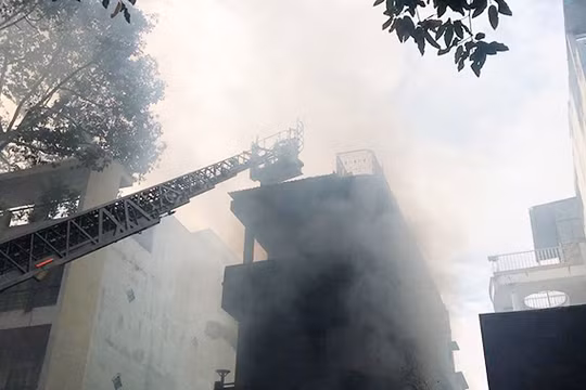 Lực lượng PCCC phải dung xe thang chuyên dung tiếp cận nóc ngôi nhà bị cháy ở Q.5 (TP.HCM) sáng nay.