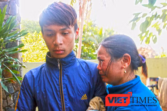 Bà Nguyễn Thị Năng (vợ ông Võ Văn Lựu, thuyền trưởng tàu QNg 90479TS) như không còn sức lực để khóc. Vùi đầu vào cậu con trai mới 16 tuổi Võ Văn Cầu trở về sau cơn hoạn nạn.