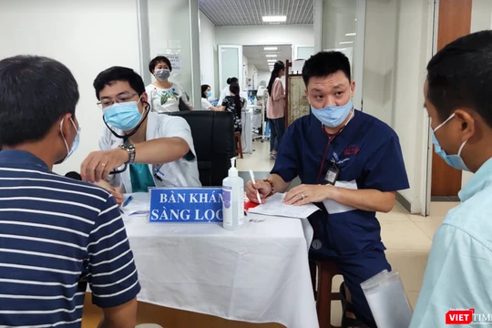 Bác sĩ khám sàng lọc cho người dân trước khi tiêm vaccine phòng COVID-19 (Ảnh - Minh Thuý) 