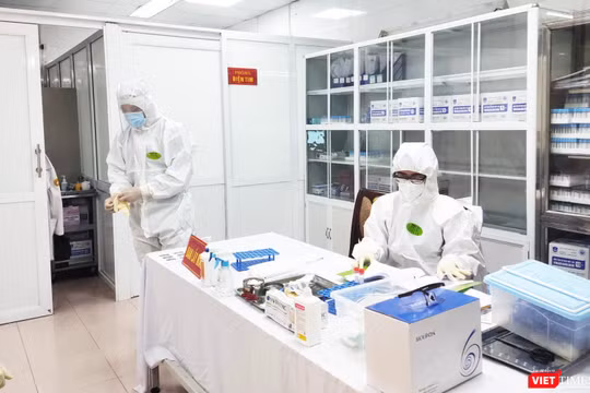 Nhân viên y tế làm việc trong phòng lấy mẫu (Ảnh - Minh Thuý) 