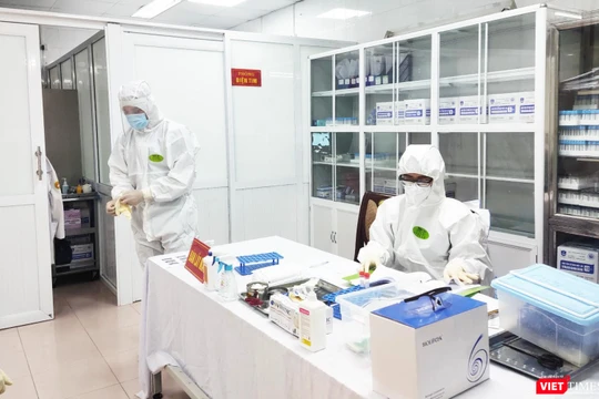 Nhân viên y tế làm việc trong phòng lấy mẫu (Ảnh - Minh Thuý) 